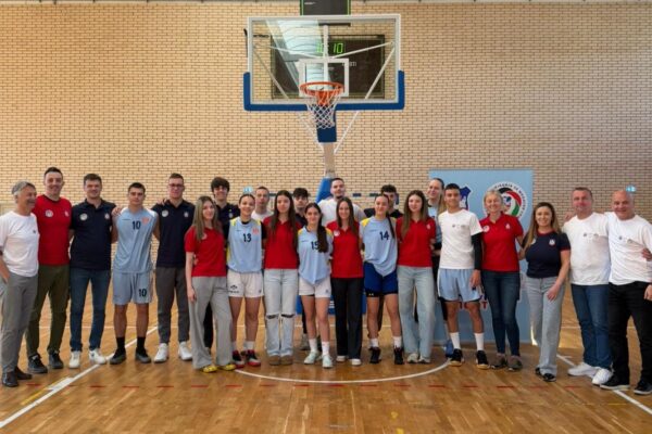 Grupna fotografija muških i ženskih košarkaških ekipa Beograda i Banja Luke sa profesorima ispod koša.