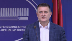 Vlado Đajić govori na konferenciji za medije ispred natpisa Narodne skupštine Republike Srpske i pokazuje dokumente Politički bukvar.